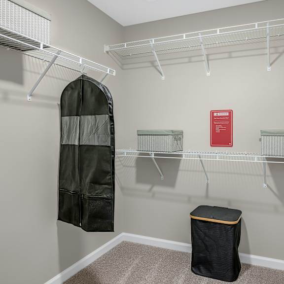 a small closet with a black bag on the floor.