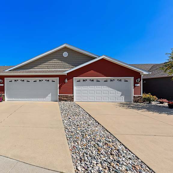 a house with a red roof and two garages.