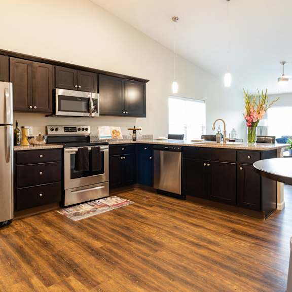 a modern kitchen with dark wood cabinets and stainless steel appliances.