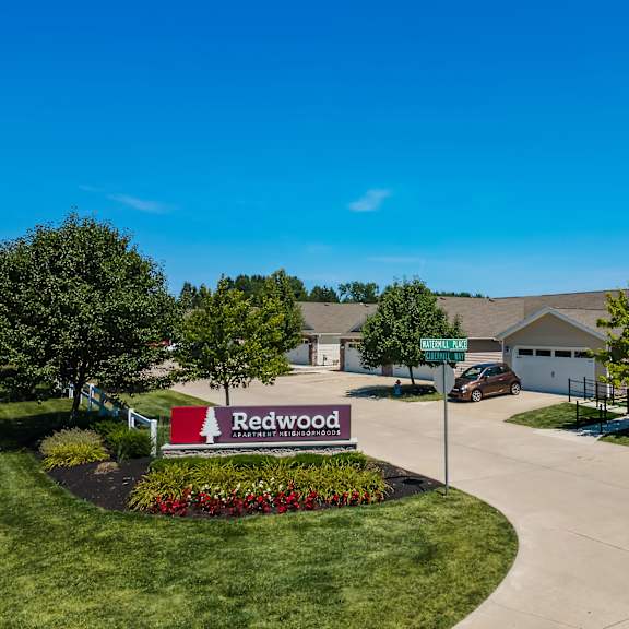 a sign for redwood stands in front of a house.