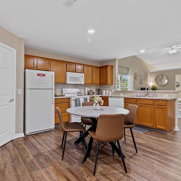 a kitchen with brown cabinets and a white fridge.