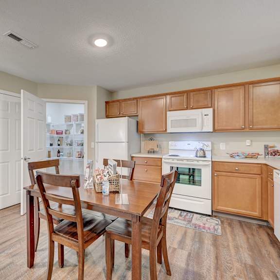 a kitchen with wooden chairs and a table.