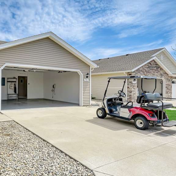 a red golf cart is parked in front of a house.