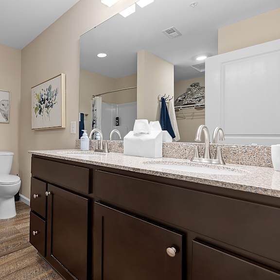 a bathroom with a toilet, sink, and mirror.