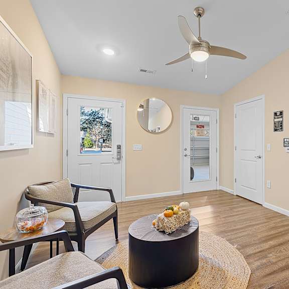 a living room with a ceiling fan and a chair.
