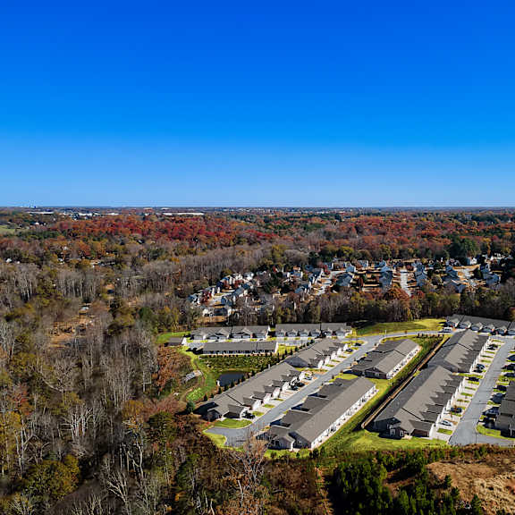 a large parking lot surrounded by trees and buildings.