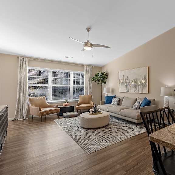 a modern living room with a dining area and a kitchen in the background.