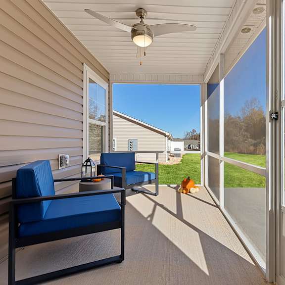 a blue chair is on a wooden deck with a ceiling fan.