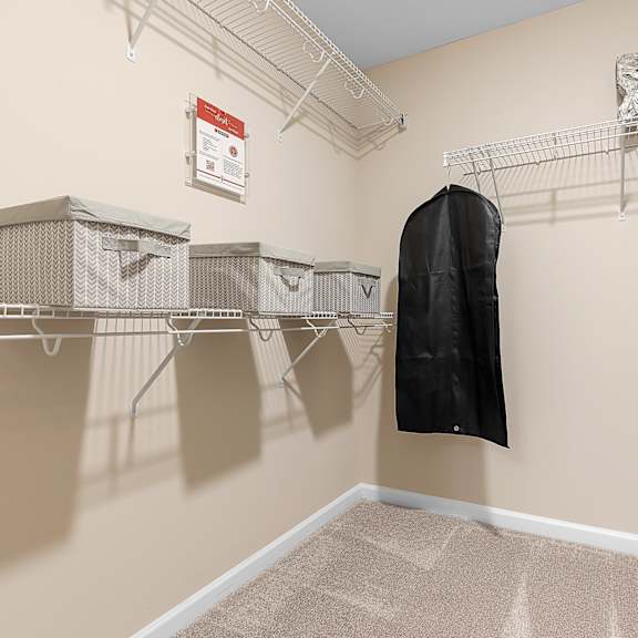 a room with a coat hanging on a rack and a sign on the wall.