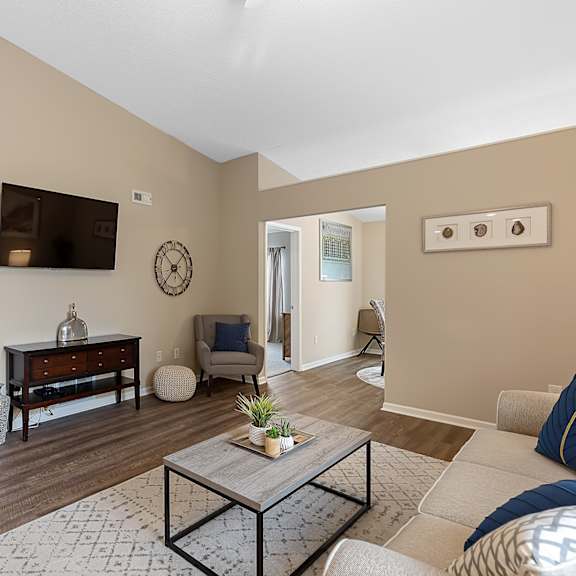 a living room with a couch, coffee table, and television.