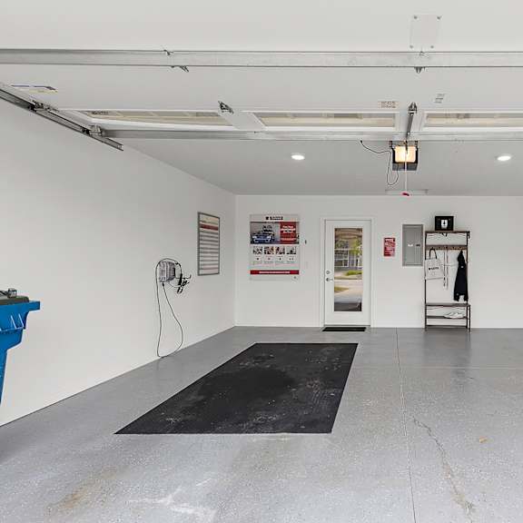 a large empty room with a black mat on the floor.