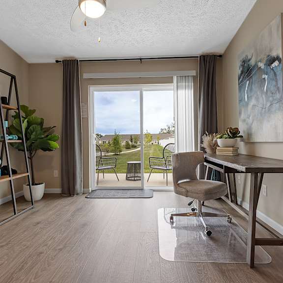 a room with a wooden floor and a large window with a view of the outside.