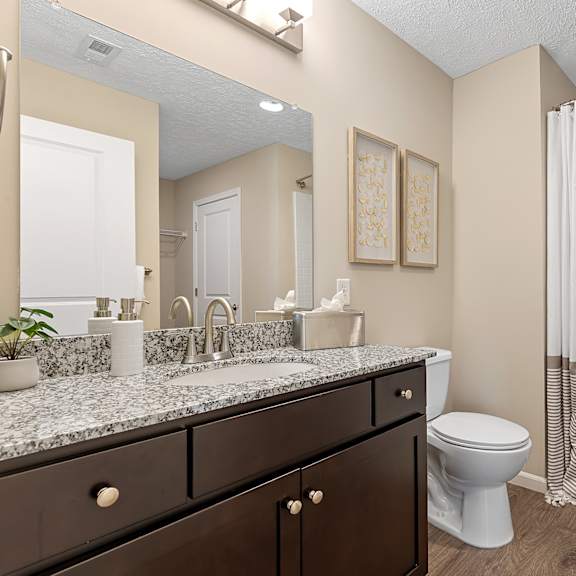 a bathroom with a white toilet and a shower with a white curtain.