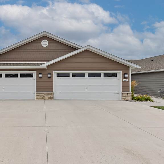 a two-car garage with a brown roof and white garage doors.