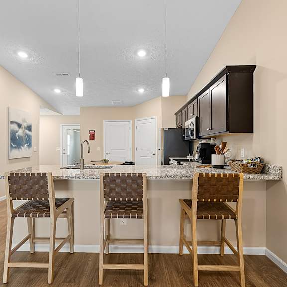 a kitchen with a bar and chairs.
