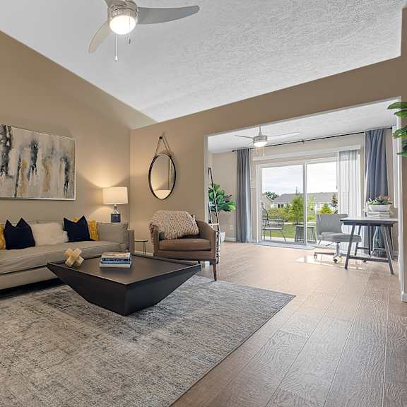 a living room with a white couch, a grey coffee table, and a painting on the wall.