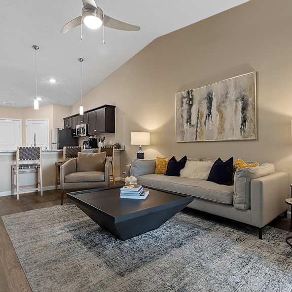 a modern living room with a grey couch, a coffee table, and a painting on the wall.
