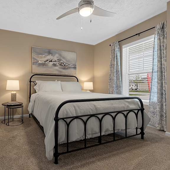 a bedroom with a large bed and a ceiling fan.