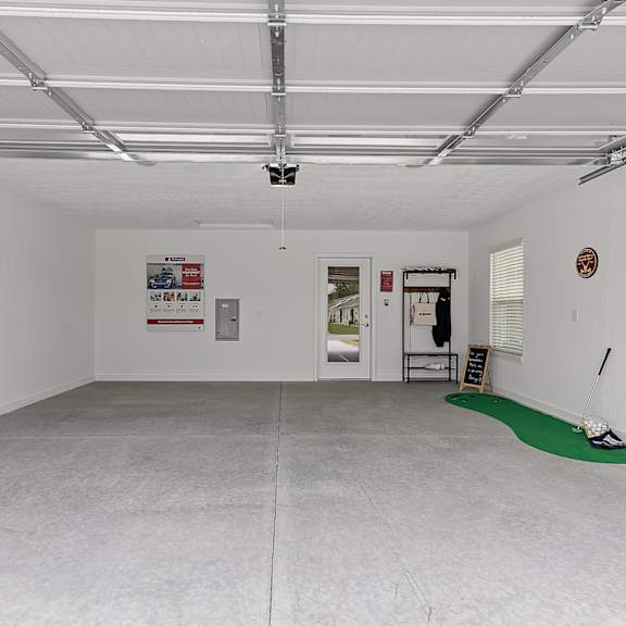 a room with white walls and a green golf mat on the floor.