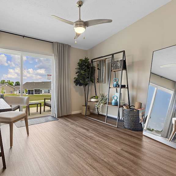 a well-lit room with a table, chairs, and a view of the outdoors through a sliding glass door.