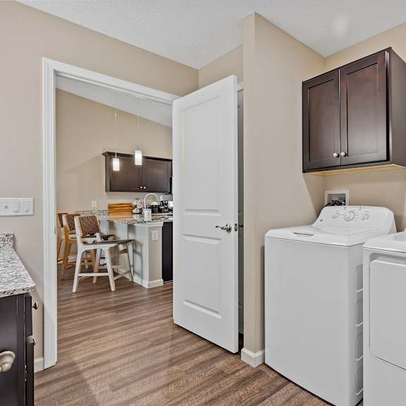 a laundry room with a washer and dryer and a basket of towels.