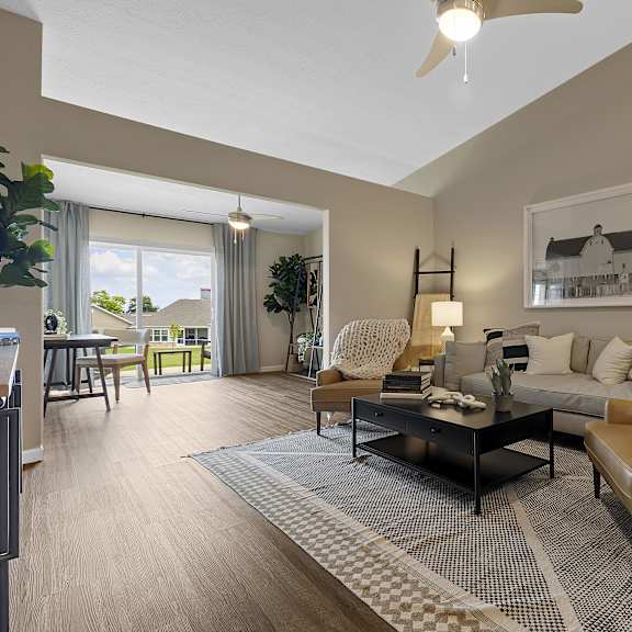 a living room with a brown leather chair and a grey and white rug.