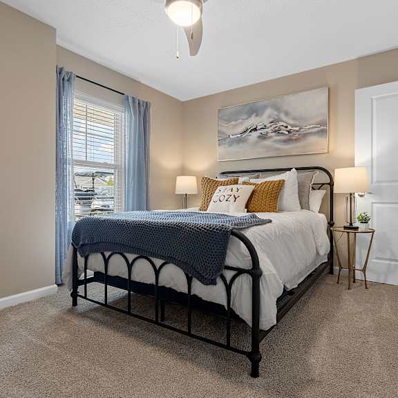 a bedroom with a bed, nightstand, and a painting on the wall.