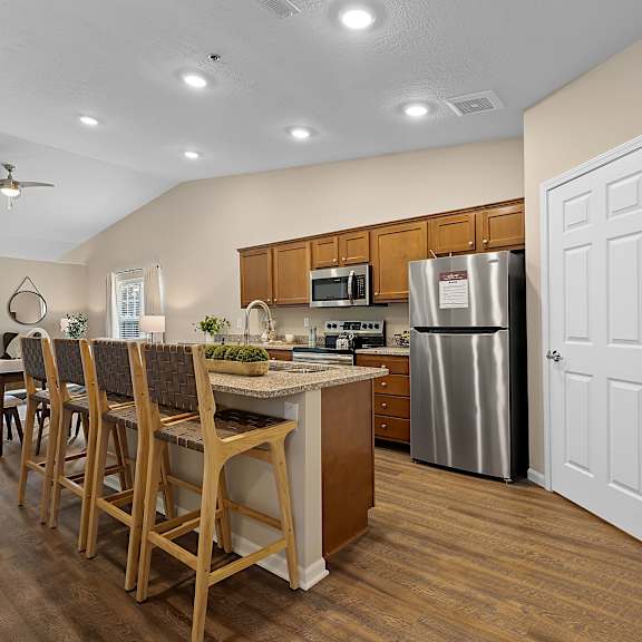 a kitchen with wooden chairs and a counter.