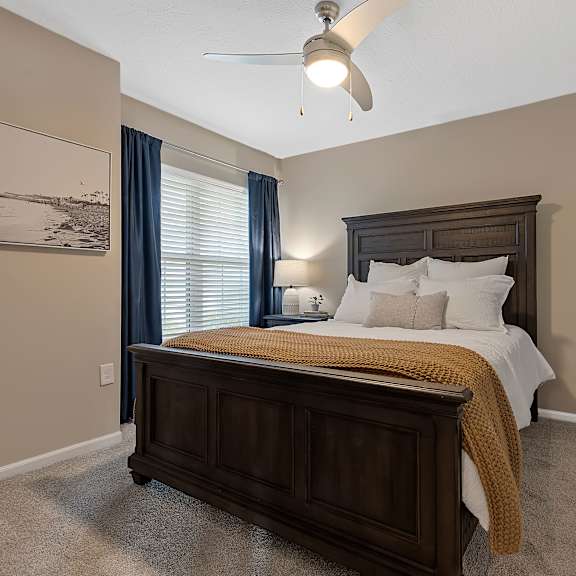 a bedroom with a large bed and a ceiling fan.