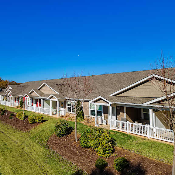 a row of houses with a sidewalk in front.