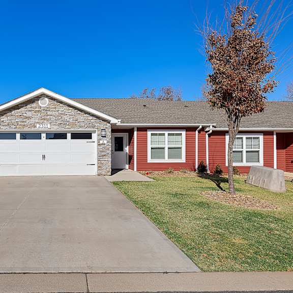 a red brick house with a white garage door.