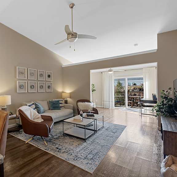 a modern dining room with a table set for six and a fan on the ceiling.