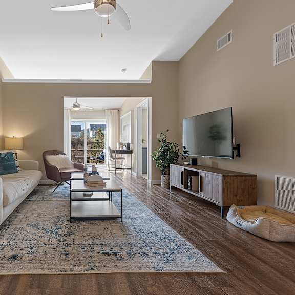 a living room with a white couch, a coffee table, and a television.