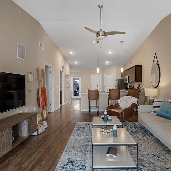 a living room with a white couch and a wooden floor.