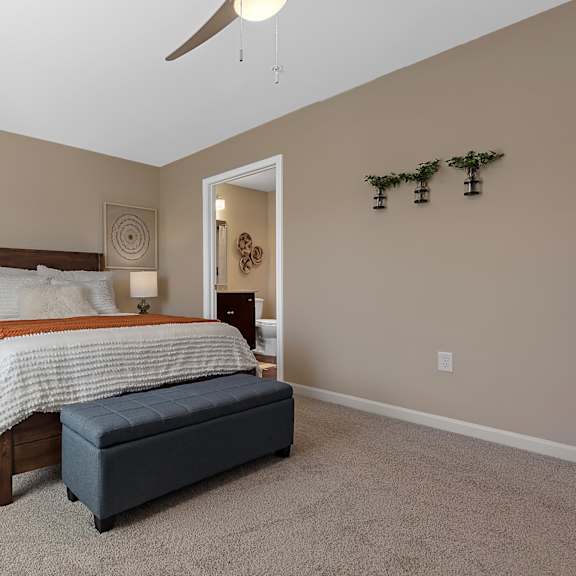 a bedroom with a large bed and a bench.