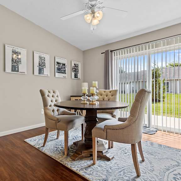 a dining room with a table set for four and a view of the backyard.