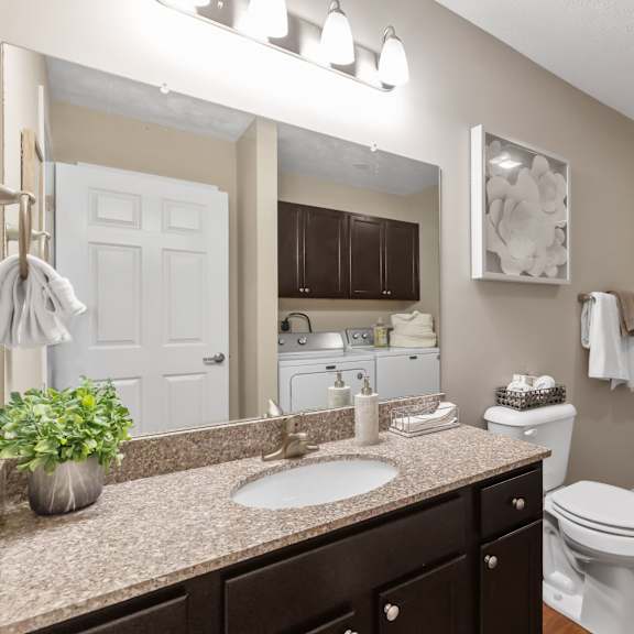 a bathroom with a white toilet, a sink, and a bathtub.