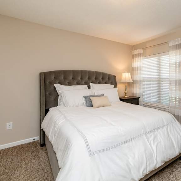a bedroom with a large bed and a painting on the wall.