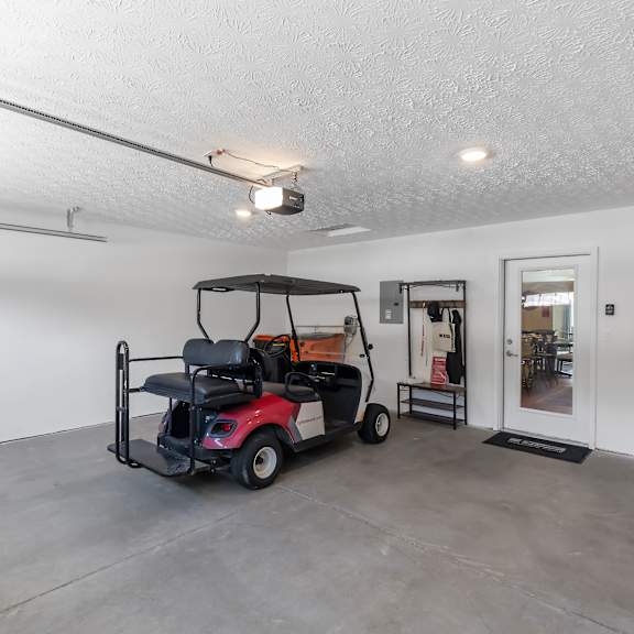 a red golf cart is parked inside a large, empty room.