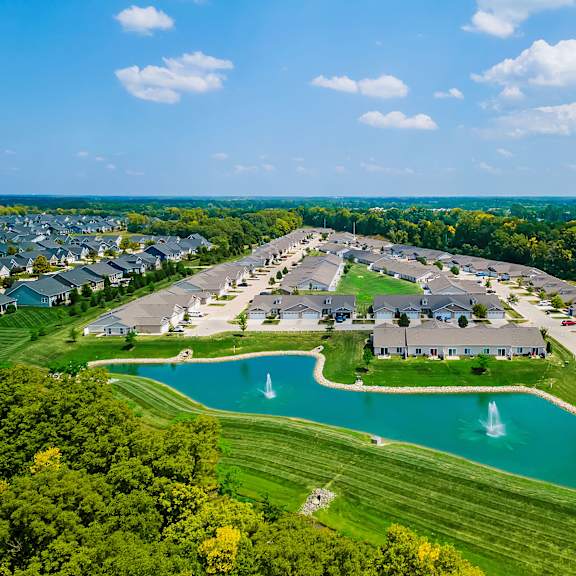 a large community with a pond and fountain in the middle.