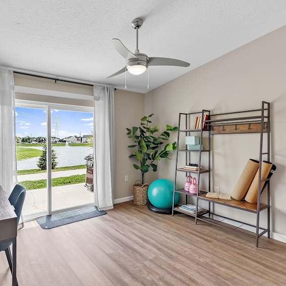 a room with a sliding glass door leading to a green lawn.