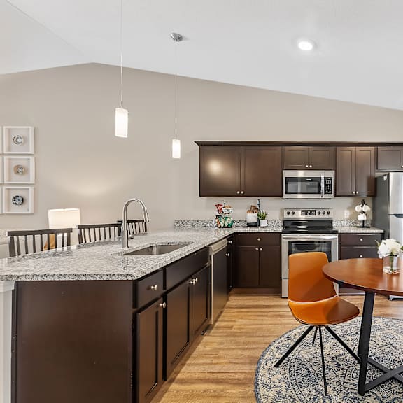 a modern kitchen with a table and chairs in the middle.