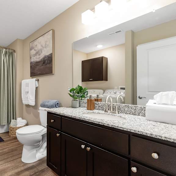 a bathroom with a white toilet, sink, and bathtub.
