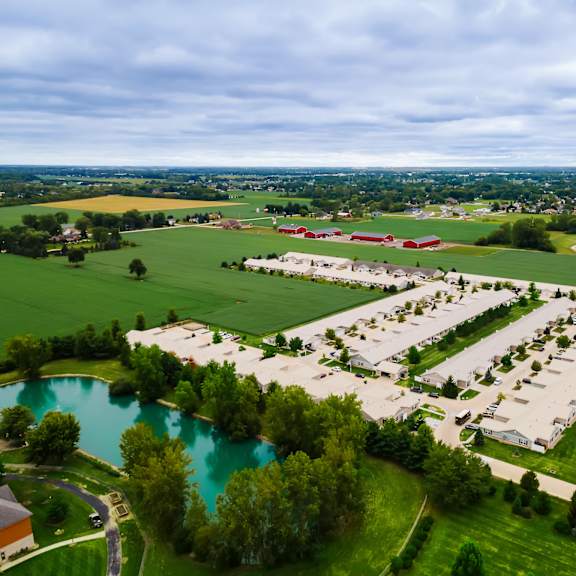 a large building complex is surrounded by a green field.