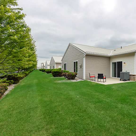 a house with a grey roof and a green lawn in front.