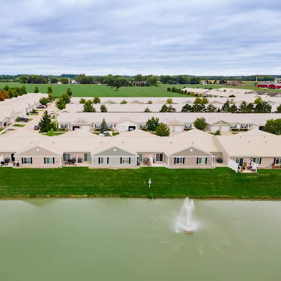 a large housing development with a pond in the foreground.