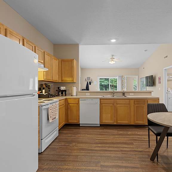 a kitchen with a white refrigerator and wooden cabinets.