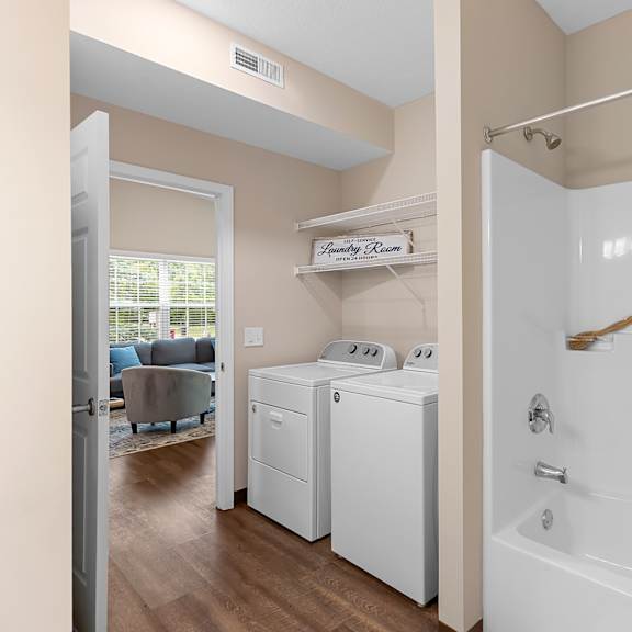 a white bathroom with a washer and dryer.