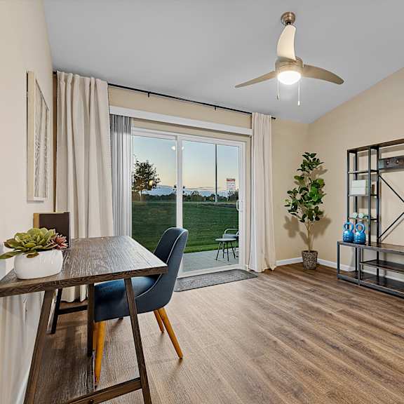 a room with a table, chairs, and a fan.