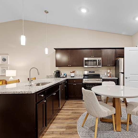 a modern kitchen with a dining table and chairs.